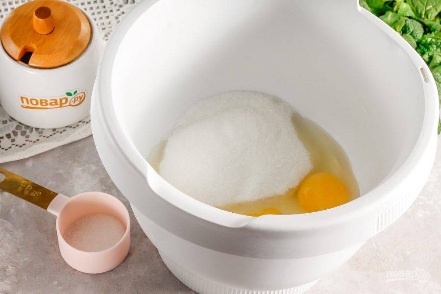 Вбейте куриные яйца в емкость миксера или кухонного комбайна. Всыпьте ванильный сахар, соль и сахарный песок. Взбейте все в течение 3-4 минут на высокой скорости техники. Желательно не переусердствовать и не взбивать большее количество времени, так как яичная масса может расслоиться.