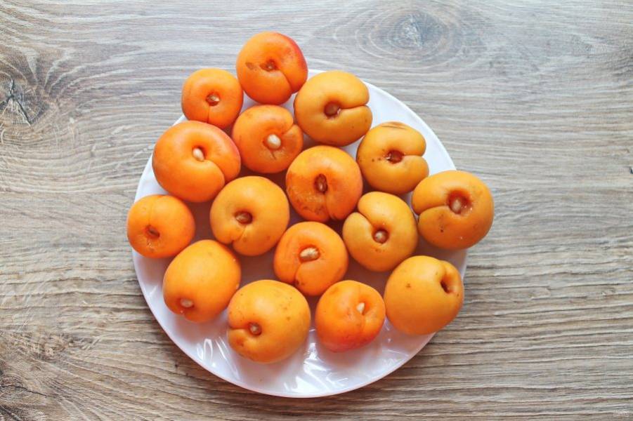 Вставьте ядрышки внутрь абрикосов через дырочки от извлечения орешек. 