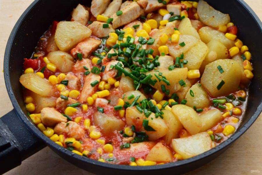 Верните обжаренные кусочки курицы, картофеля, доведите до кипения, посыпьте оставшимся зеленым луком.