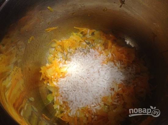 3. Добавляем промытый рис, перемешиваем и обжарим еще минутку, помешивая.
