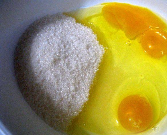 В миску вбиваем яйца, добавляем сахар.
