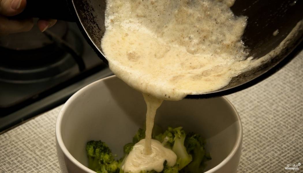3. На дно горшочка выкладываем измельченный чеснок и тертый сыр, затем - брокколи, и затем все это заливаем соусом. По желанию можно оставить немного сыра, чтоб посыпать блюдо сверху. 