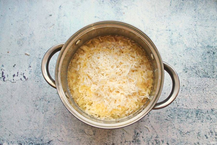 Плавленый сыр натрите на средней терке и положите в кастрюлю с овощами. Варите все еще 5-10 минут, перемешивая. Сыр должен полностью расплавиться.