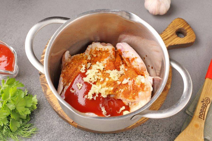 Добавьте к крылышкам горчицу, кетчуп, давленый чеснок, соевый соус, соль и специи по вкусу.