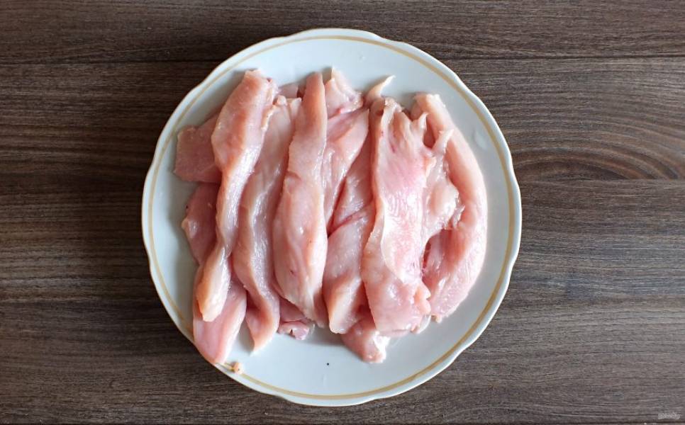 Куриное филе нарежьте по длине грудки на полоски.