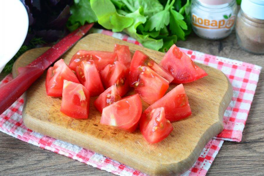 Промойте помидоры и нарежьте средними кусочками.