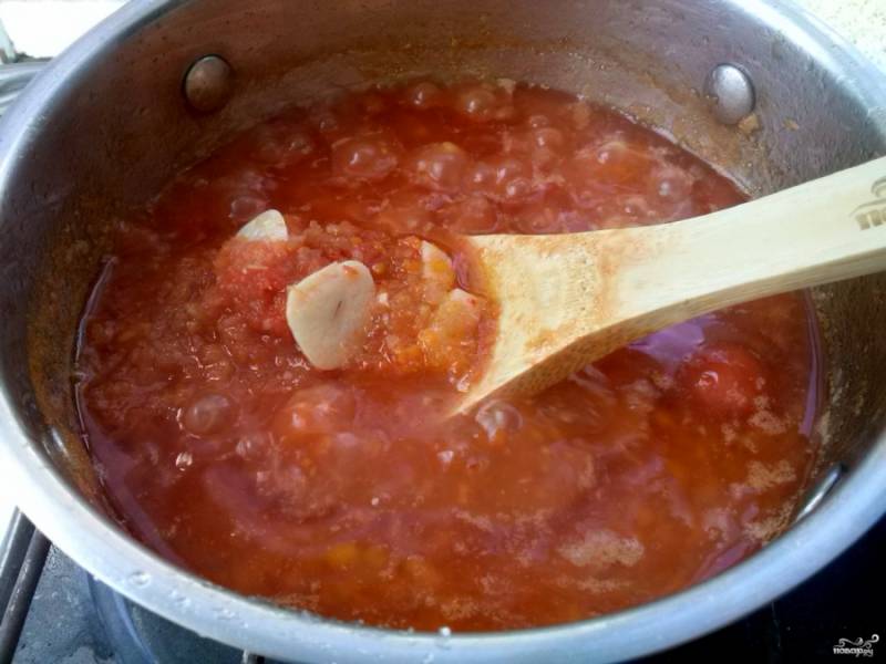 Добавьте томатный сок. Если используете томатную пасту, ее понадобится 1/2 стакана. Подливу доведите до кипения. Варите 20 минут, периодически помешивая. Добавьте измельченный чеснок, проварите 10 минут.