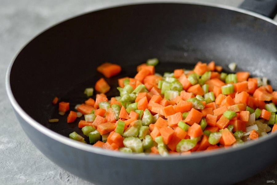 Морковь и сельдерей нарежьте кубиками. Добавьте овощи на сковороду и жарьте несколько минут. 