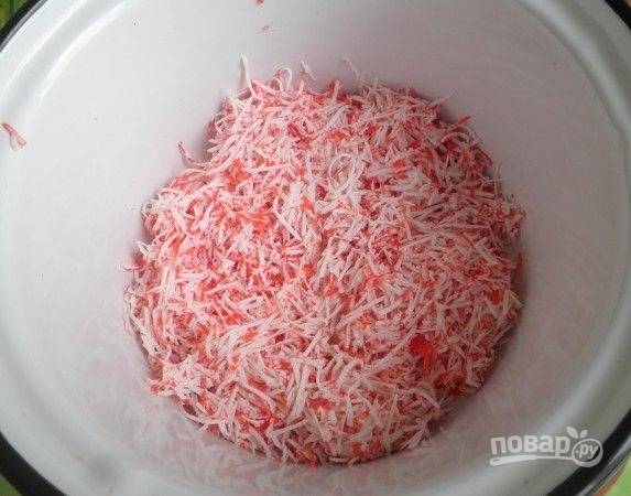 1. Первым делом сварите вкрутую яйца и остудите. Крабовые палочки очистите и натрите на терке.