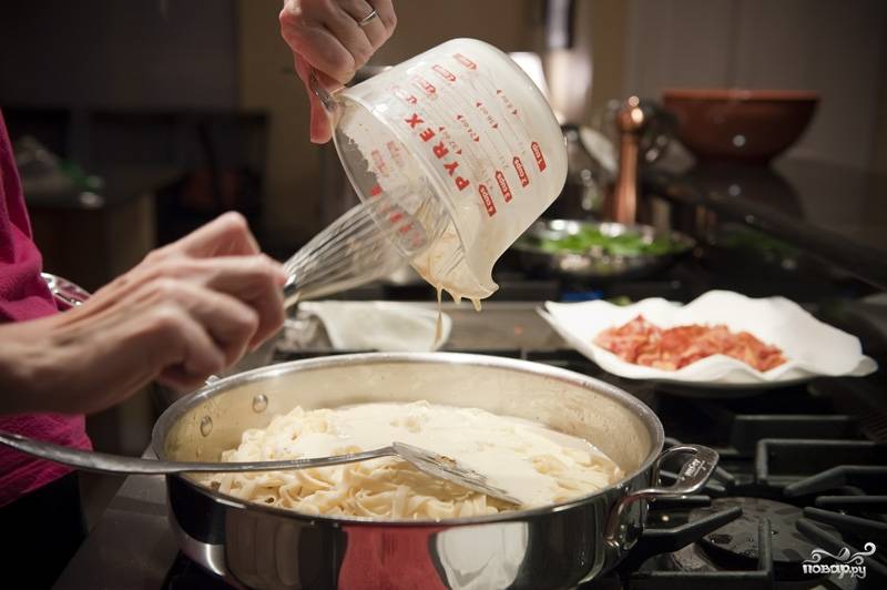 В этой же сковороде, на среднем огне обжариваем лук и чеснок до золотистого цвета. К этому моменту паста уже должна быть готова, отбрасываем ее на дуршлаг и выкладываем ее к луку. В пасту выливаем готовую смесь.