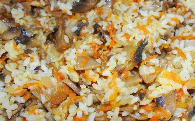Смешать отваренный рис с обжаренными грибами, луком и морковкой.
