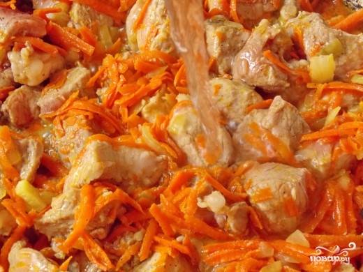 2. На растительном масле обжариваем свинину, нарезанную кусочками среднего размера. В середине жарки добавляем лук, а затем морковь. Жарим до готовности.