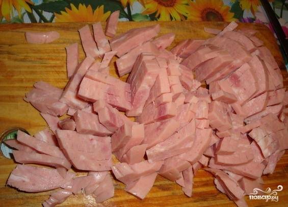 2. Нарежьте ветчину ровными полосками (соломкой). Можно использовать и копченое мясо с жировыми прослойками.