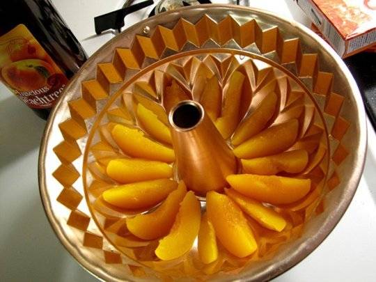 1. На дно выбранной формы выложить дольки персиков. Для этих фруктов очень удобно использовать именно форму для кексов. Еще при приготовлении желейного торта с фруктами можно использовать сразу несколько видов фруктов и несколько слоев цветного желе, например. 