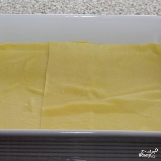 В слегка смазанную маслом форму для запекания выкладываем слой листов для лазаньи (если форма и листы не соответствуют друг другу по размерам, листы можно разрезать).