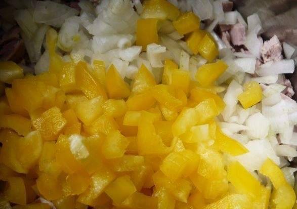 4. Поместите уж нарезанные ингредиенты в большую емкость. После этого нарежьте болгарский перец. Советую взять перец разных цветов - так вы придадите дополнительных красок салату.