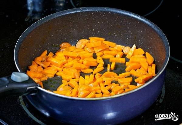 1. Очистите морковь и нарежьте небольшими кусочками. На сковороде с высокими бортами разогрейте растительное масло и обжарьте морковь пару минут. 