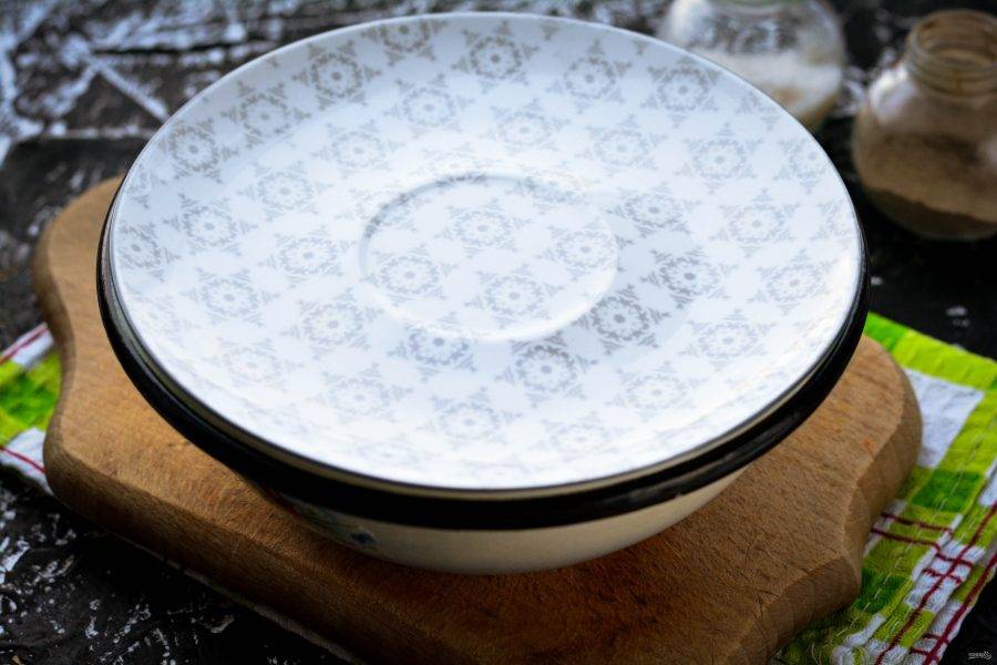 Прикройте миску поплотнее, можно взять небольшую тарелку или крышку. Оставьте капусту кваситься на столе на 2 суток, затем переставьте еще на двое суток в холодильник.