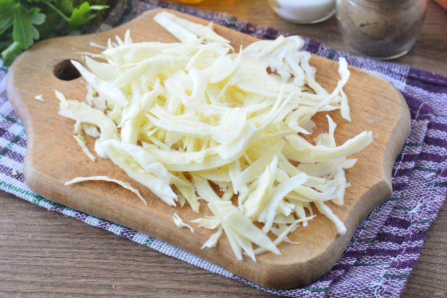 Нашинкуйте капусту тонкими полосками.