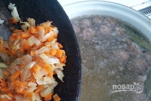 Добавьте зажарку в суп. Помимо неё внесите карри или куркуму, соль, перец и зелень.