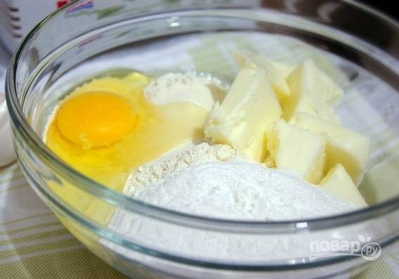 1. В глубокой мисочке соедините ингредиенты для теста: муку, яйцо, сахар, масло. Добавьте щепотку соли и разрыхлителя. 