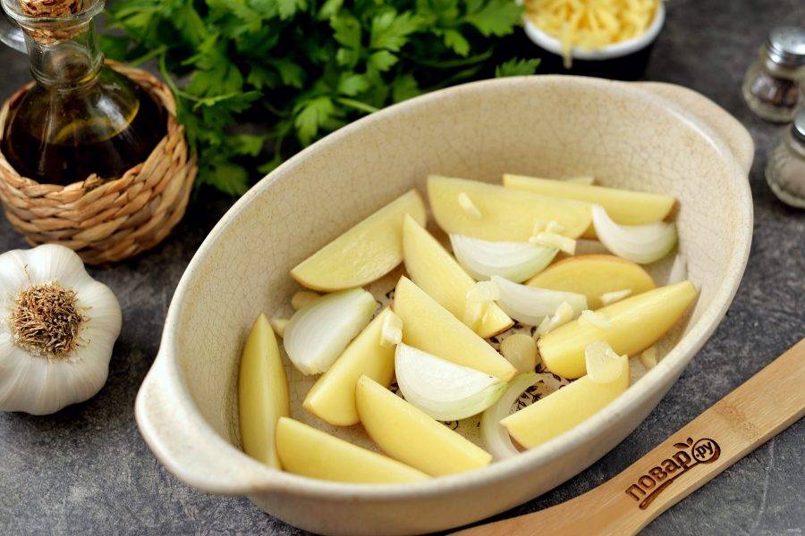 Нарежьте картофель дольками, измельчите лук и чеснок, все овощи сразу же переложите в огнеупорную форму.  