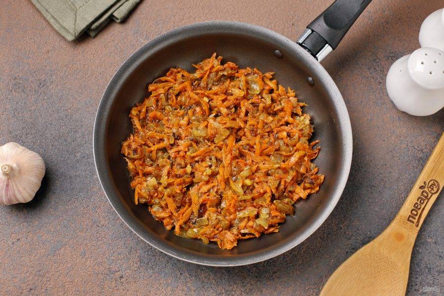 Тем временем обжарьте в сковороде с добавлением специй нарезанный кубиками лук и тёртую морковь.
