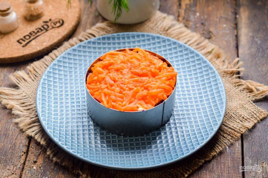 Завершающий слой — натрите морковь на средней терке и выложите поверх свеклы. Пропитайте салат часик и подавайте к столу.