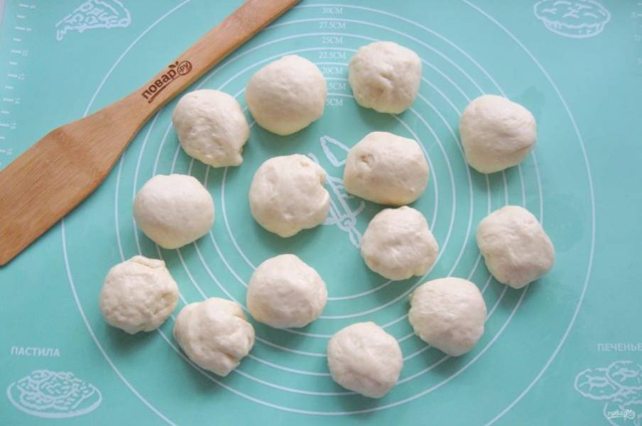 Когда тесто подошло, достаньте его из миски, обомните и разделите на шарики весом 60-70 грамм.