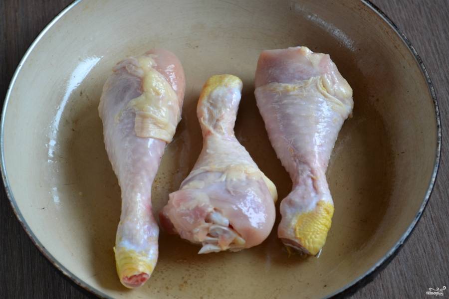 Выложите куриные голени в сковороду с разогретым подсолнечным маслом и обжаривайте до румяной корочки.