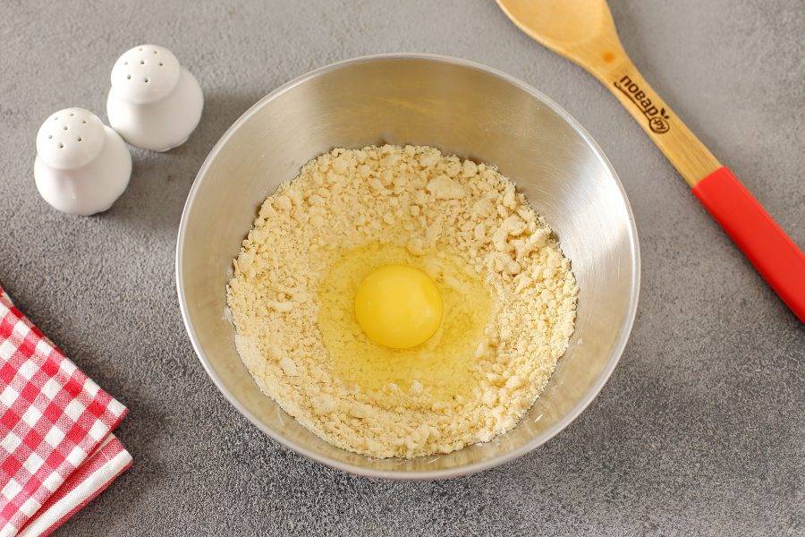 Перетрите все руками до состояния крошки и добавьте одно яйцо.