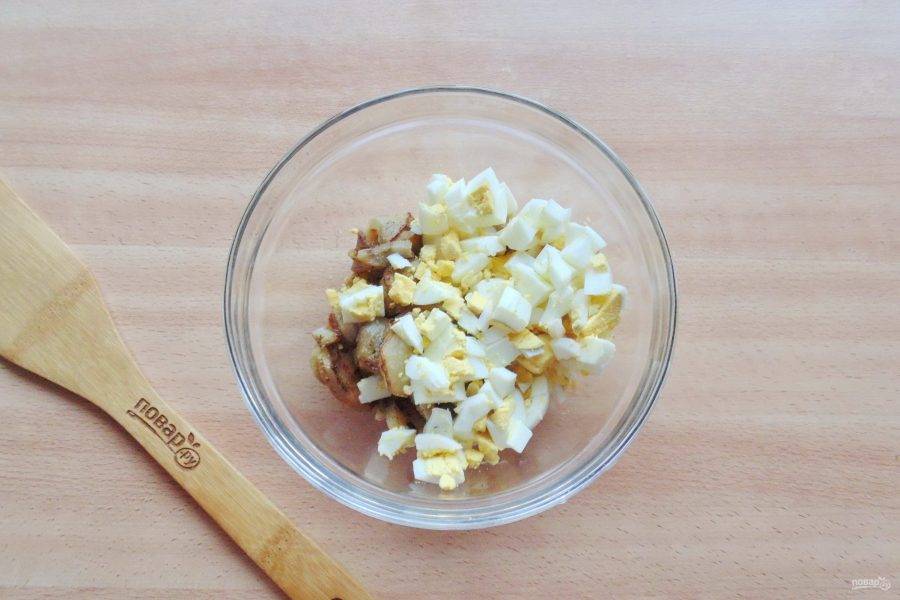 Яйца сварите вкрутую, охладите и очистите. Нарежьте кубиками и добавьте в миску с баклажанами.