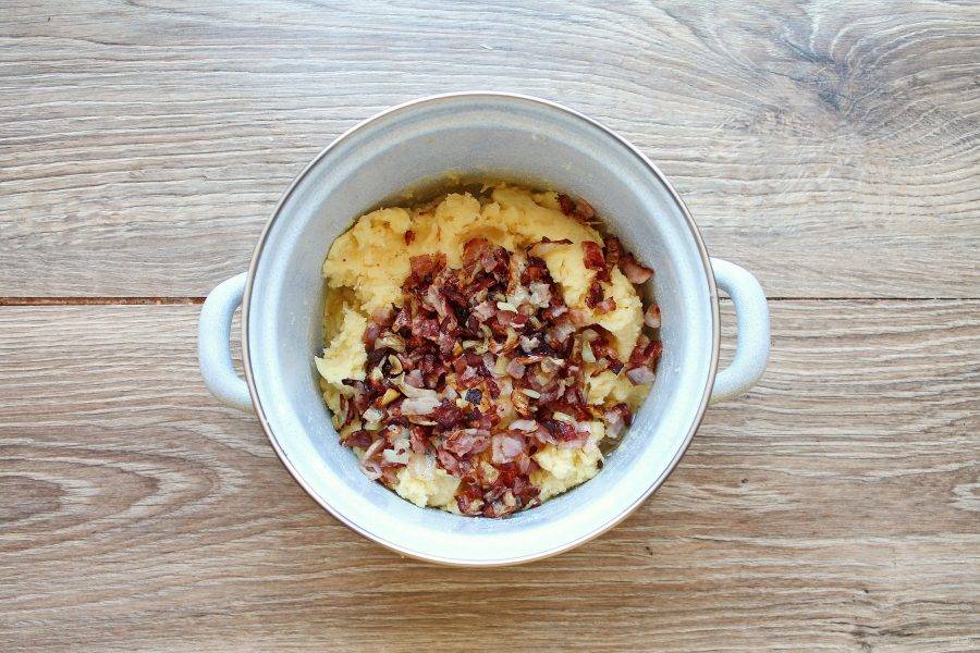 Добавьте обжаренный бекон с луком в картофельное пюре с сыром и перемешайте.