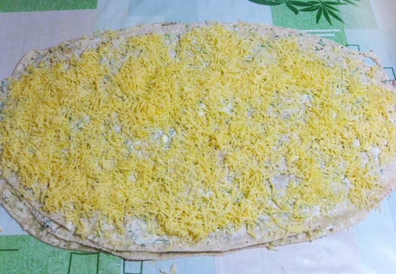 На этот слой выкладываем третий лаваш, опять смазываем его оставшимся майонезом и посыпаем тертым сыром. 