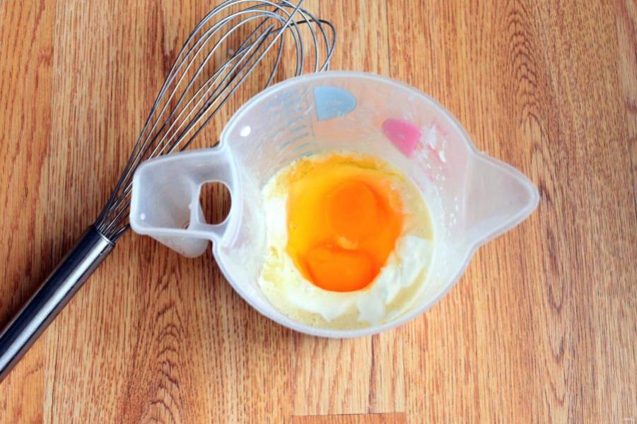 Добавьте яйца и сметану, хорошо перемешайте венчиком.