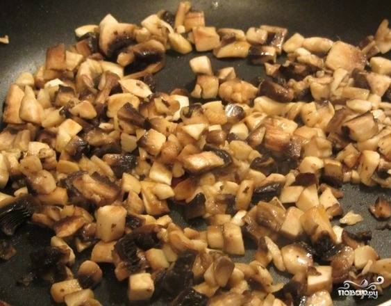 Грибочки хорошенько вымойте и порубите на небольшие квадратики. Обжарьте их на сковороде с подсолнечным маслом без запаха до полуготовности. Если хотите, можете добавить к грибам мелко нарезанный лучок, который подчеркнет их вкус и аромат. 