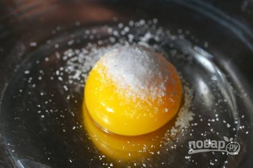 В миску положите яичный желток и добавьте соль.