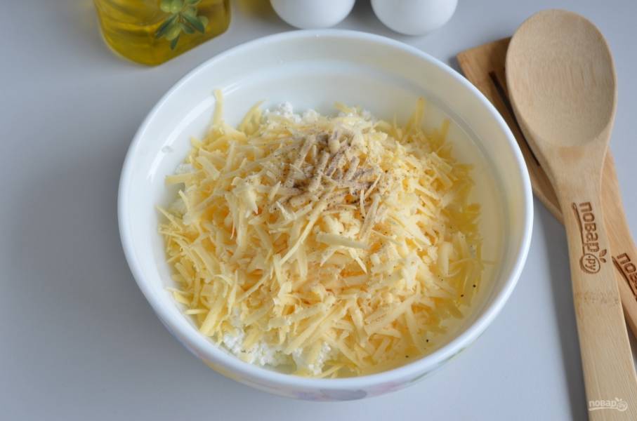 Для начинки соедините творог с тертым сыром и тертым сливочным маслом, щепоткой соли и перца черного молотого.