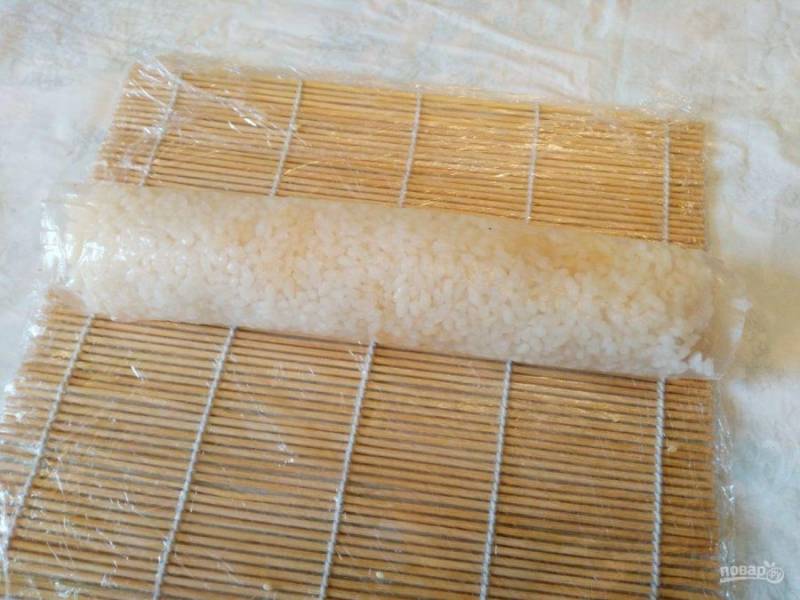 Сверните ролл с рисовой бумагой, при необходимости смачивая водой подсыхающие края бумаги, чтобы не допустить трещин.