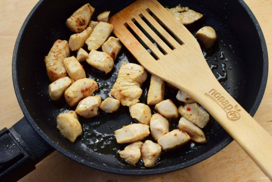 Нагрейте оливковое масло (1 ст. л.) на сковороде. Обжарьте куриное мясо до румяной корочки около 2 минут. Выложите в миску.
