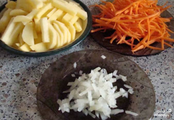 Овощи моем, чистим. Картофель нарезаем ломтиками, морковь трем на терке, а лук измельчаем.