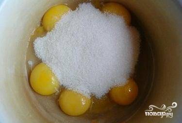 Остальной сахар взбейте с желтками. Добавьте ванильный сахар. Продолжайте взбивать до белого цвета.