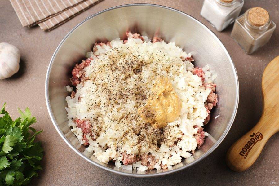 Переложите фарш в глубокую миску, добавьте отжатый батон, горчицу, нарезанный мелкими кубиками лук, давленый чеснок, соль и перец по вкусу.