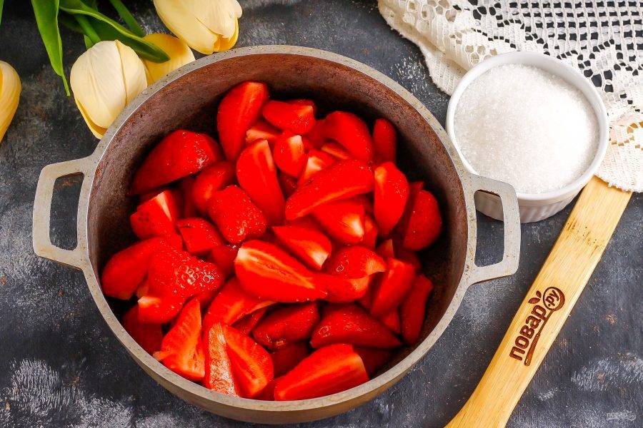 Нарежьте ягоды слайсами или на четвертинки, выложите нарезку в казан, кастрюлю или в ковш с антипригарным дном.