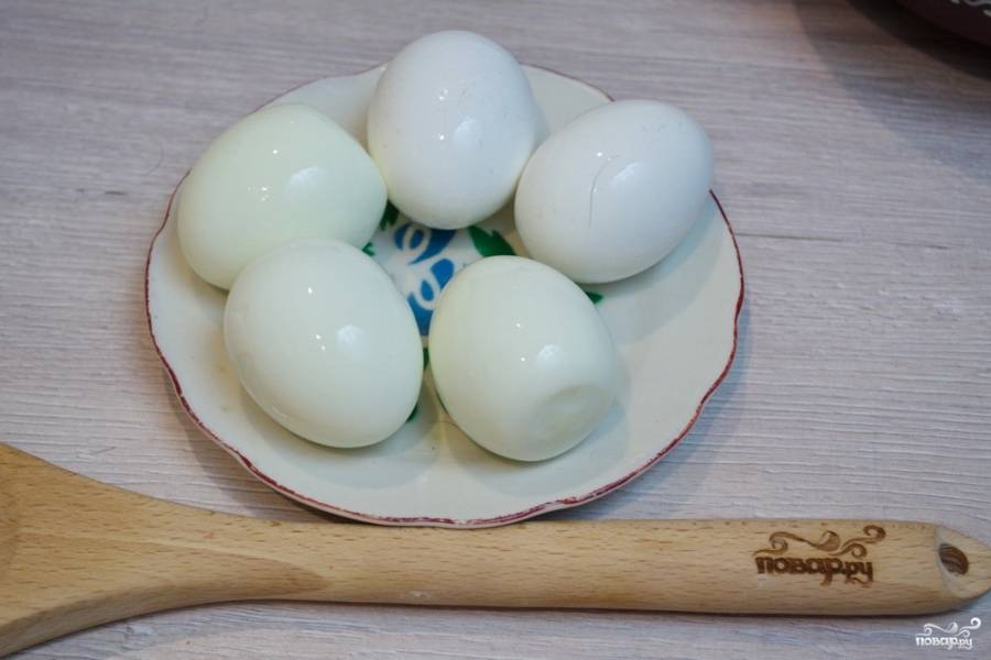 Отварите куриные яйца. Очистите их и хорошо остудите. Теплые куриные яйца будут ломаться при нарезании.