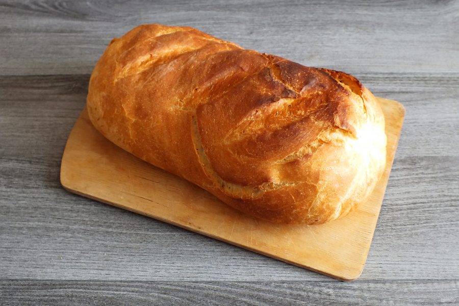 По истечении времени достаньте хлеб из духовки и сразу же снимите рукав для запекания. Переложите хлеб на доску, охладите. После подавайте к столу.