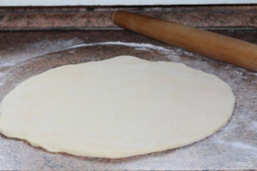 Готовое тесто раскатайте в лепёшку по диаметру формы для выпечки.