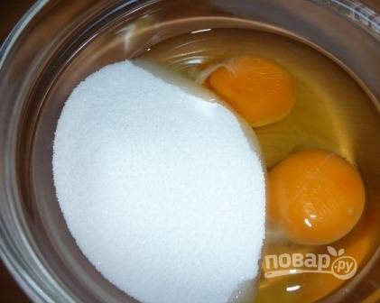 В миску выбиваем яйца и добавляем сахар.