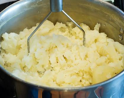 Сливаем почти всю воду, разминаем картофель в оставшемся отваре. Можно воспользоваться блендером. Пюре должно быть без комочков, теплым и нежным.