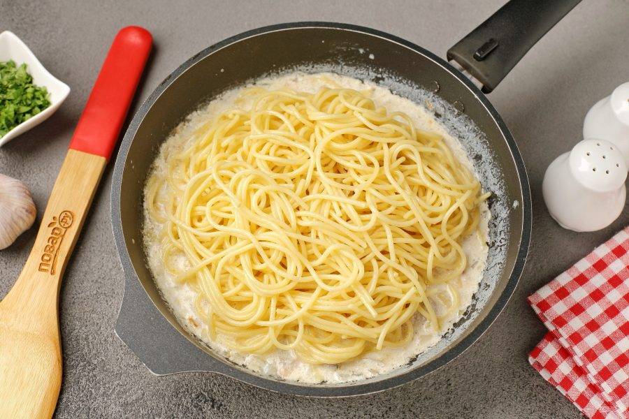 Когда соус закипит, добавьте предварительно отваренные спагетти. Я обычно отвариваю параллельно приготовлению соуса, что значительно экономит время. Готовьте спагетти в подсоленной воде согласно инструкции на упаковке.